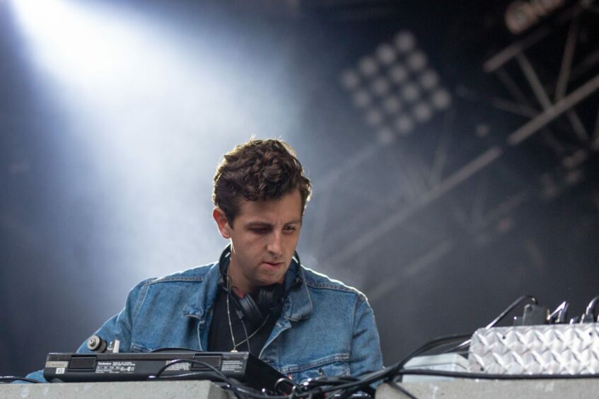 Jamie XX on stage at a music festival.