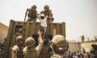 United Kingdom coalition forces, Turkish coalition forces, and United States Marines assist a child during an evacuation at Hamid Karzai International Airport, Kabul, Afghanistan, in August 2021