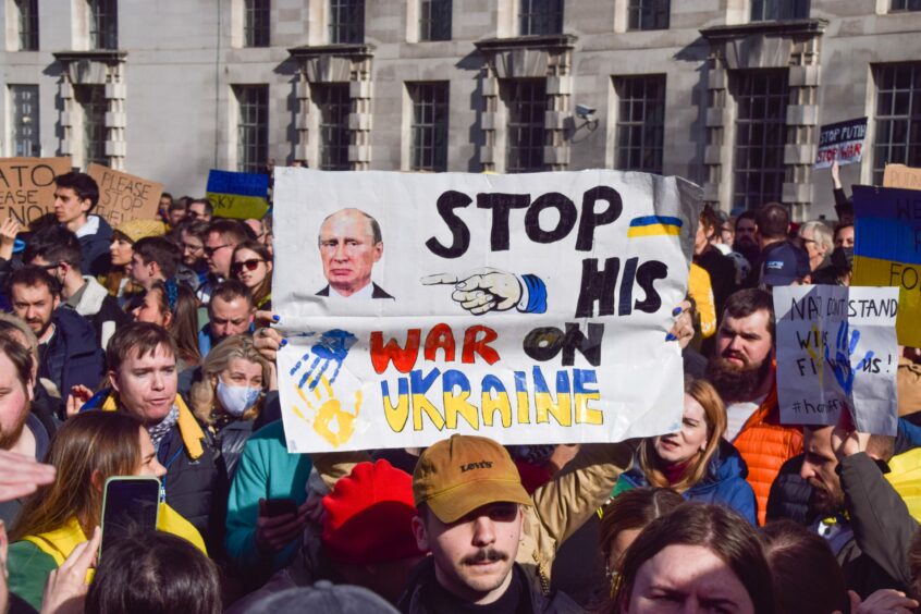 Protestors hold up sign calling for Putin to stop his war on Ukraine