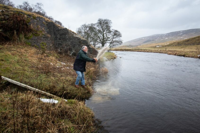 Colin Whelan scatters his mother's ashes on the river