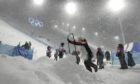 Volunteers clear the course as the women's aerials qualification has been delayed due to  weather conditions at the 2022 Winter Olympics. AP Photo/Lee Jin-man