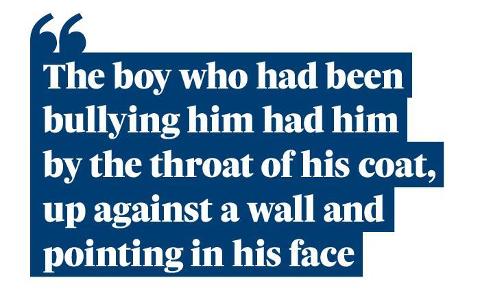 Quotation: The boy who had been bullying him had him by the throat of his coat, up against a wall and pointing in his face."