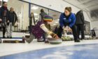 Sadie Sayers-Lodge, 10, watched by mum Andrea, grandad  Mike and coach Lorraine Campbell tried curling for the first time at Forfar. Pic: Alan Richardson.
