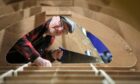 Ian Dickson of Forfar Men's Shed working on the St Ayles skiff. Pic: Gareth Jennings/DCT Media.