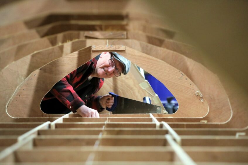 Ian Dickson from Forfar Men's Shed at work on the skiff early in 2022