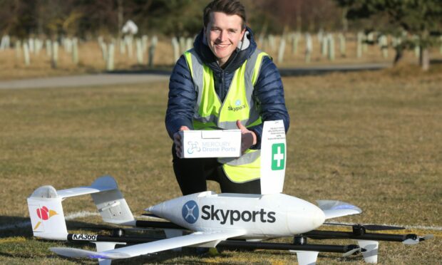 Skyports Flight Operations Manager Alistair Skitmore places a medicine box in the drone.