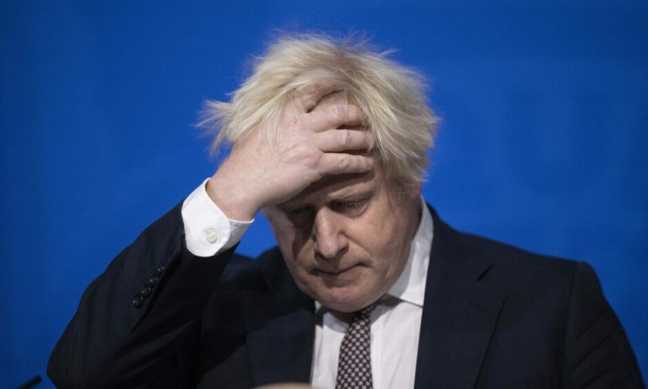 Photo shows Boris Johnson with his head in his hands.