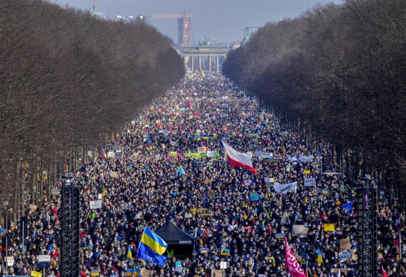 People walk down the bulevard 'Strasse des 17. Juni' ahead of a rally against Russia's invasion of Ukraine in Berlin, Germany