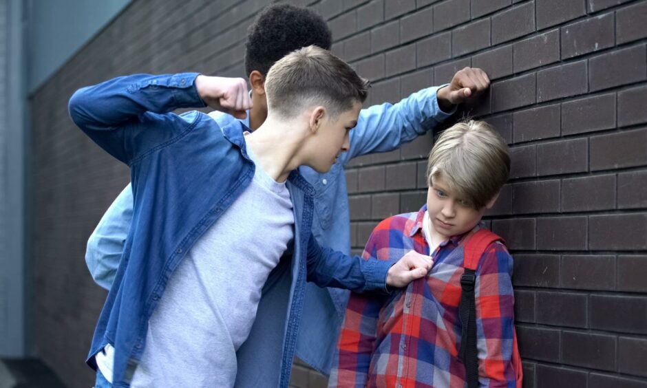 Two older boys bullying and threatening to punch a younger boy