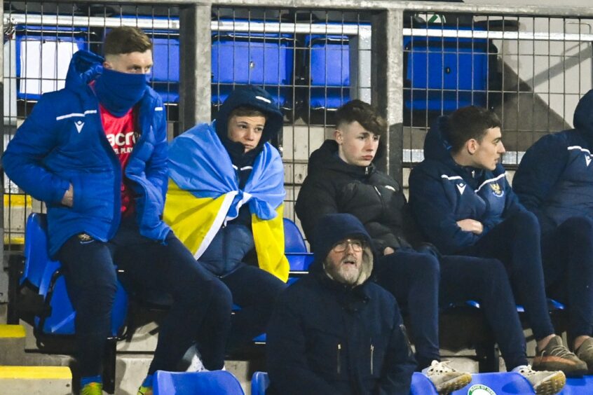 Max Kucheriavyi, draped in a Ukrainian flag, watches St Johnstone v Rangers.