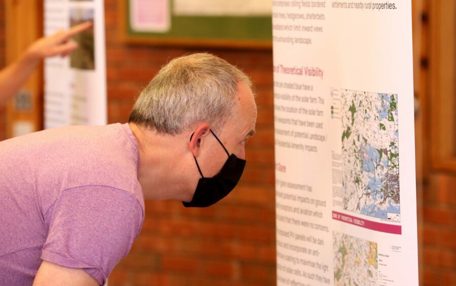 A local man considers the solar plans at a public engagement event in June.