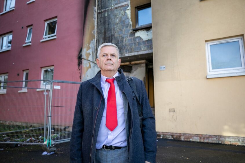 Labour councillor Charlie Malone at the front the fire damaged block of flats in Dundee