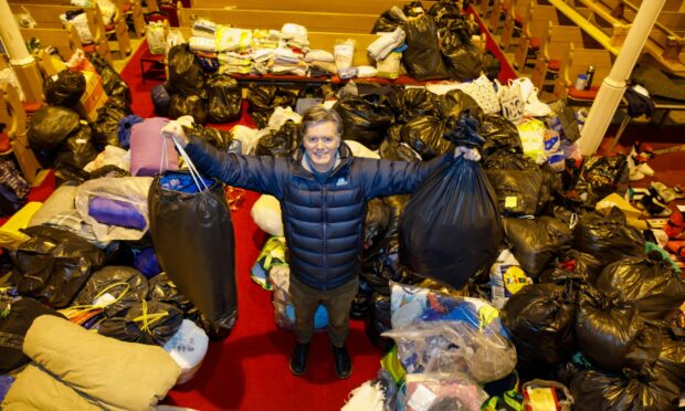 The Reverend Dr Nathan McConnell with £10,000 of aid collected from locals at Downfield Mains Church, Dundee.