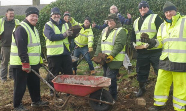 Residents and Rotarians clear the Noran Avenue site. Pic: Arbroath Rotary Club.
