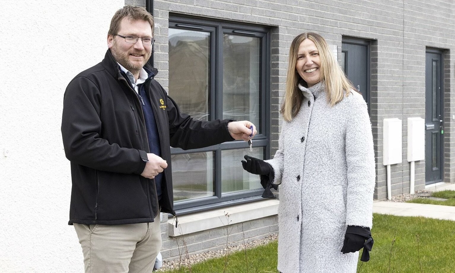 Director of Sunnyside Estate David Stewart hands over the keys of 12 new affordable homes to Hillcrest Homes deputy chief executive Fiona Morrison.