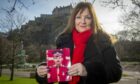 Theresa Davidson with photo of husband Clark Mitchell in front of Edinburgh Castle
