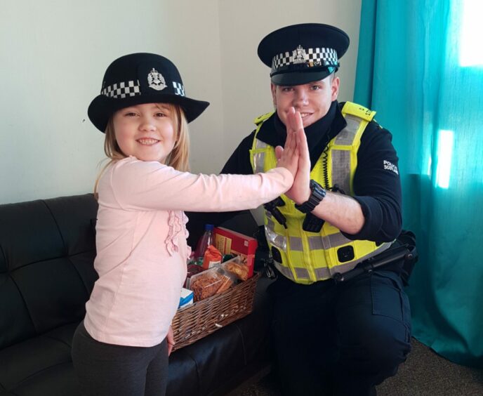 Libby handing over the hamper to PC Ewan Cunningham.