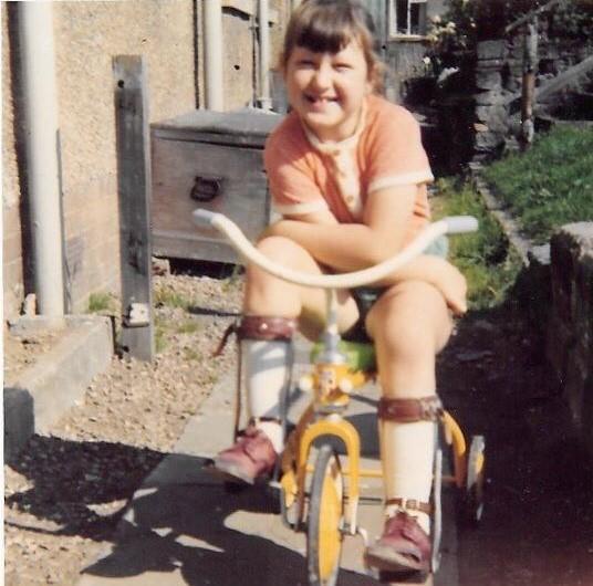 Petra Ryce shown as a child sitting on her trike.