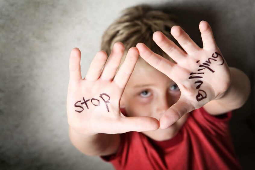a boy with 'stop bullying' written on his hands