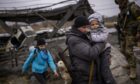 Families flee across a bridge destroyed by artillery on the outskirts of Kyiv. Photo: Emilio Morenatti/AP/Shutterstock.