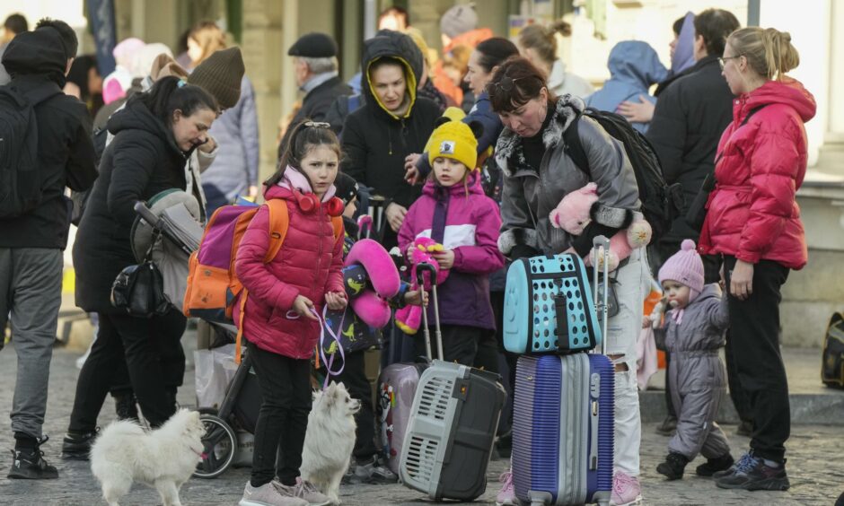Refugees with children wait for a transport in Poland after fleeing the Russian invasion into Ukraine