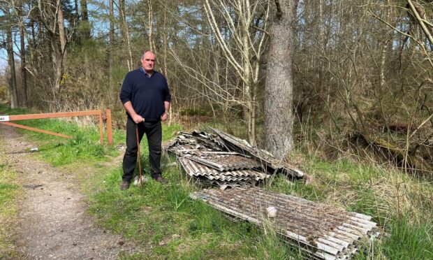 Gavin Nicol with the sheets of deadly asbestos dumped in woodland near Brechin.