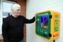 George McLure with the new defibrillator close to the scene of his September brush with tragedy. Pic: Gareth Jennings/DCT Media.