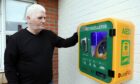 George McLure with the new defibrillator close to the scene of his September brush with tragedy. Pic: Gareth Jennings/DCT Media.
