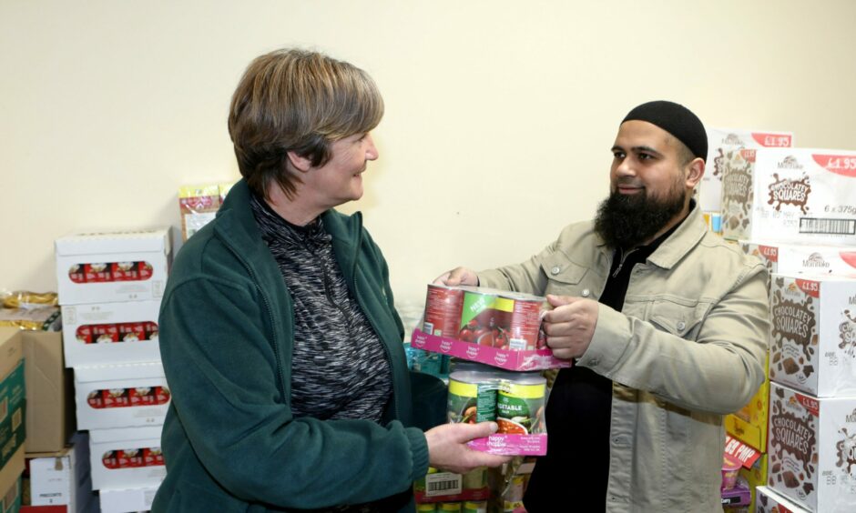 Iftekhar Yaqub and Lindsay McCowan with tinned items being donated.