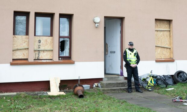 Police stand guard outside the house on Lundie Avenue.