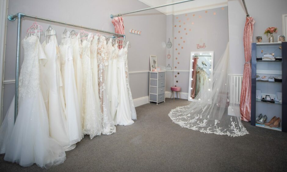 A rack of wedding dresses inside Azura Couture.