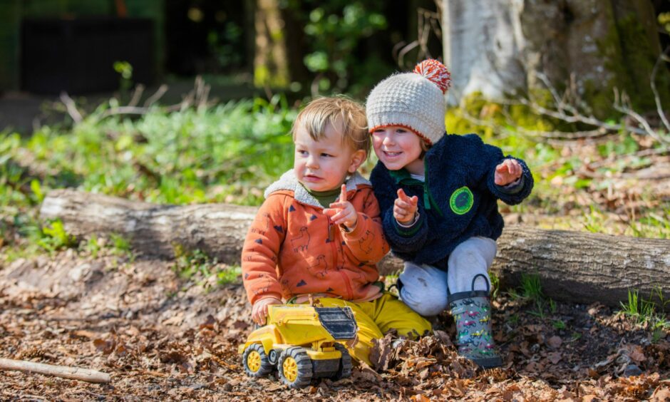 Two children in woods enjoying outdoor play