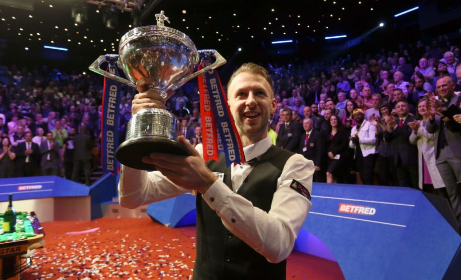 Judd Trump celebrates with the World Championship trophy.