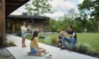 ©Husqvarna family relaxing blowing bubbles while automated lawn mowers cuts the grass