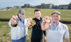 l-r Bonnie Wee Golf managing director Dave Harris, tour specialist Cam Howe and director Stew Morrison show off commemorative coins golfers can get on the Old Tom Morris Trail.
