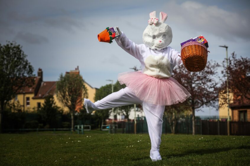 Easter bunny with basket of eggs in a park