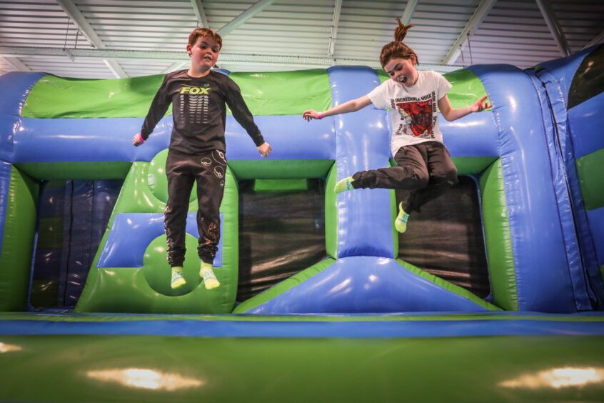 two children bouncing on an inflatable playground