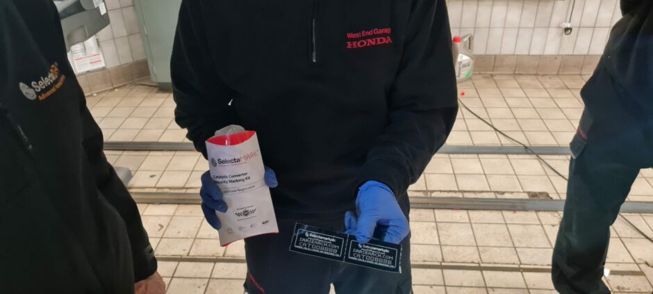 Dundee Honda staff with catalytic converter theft prevention stickers