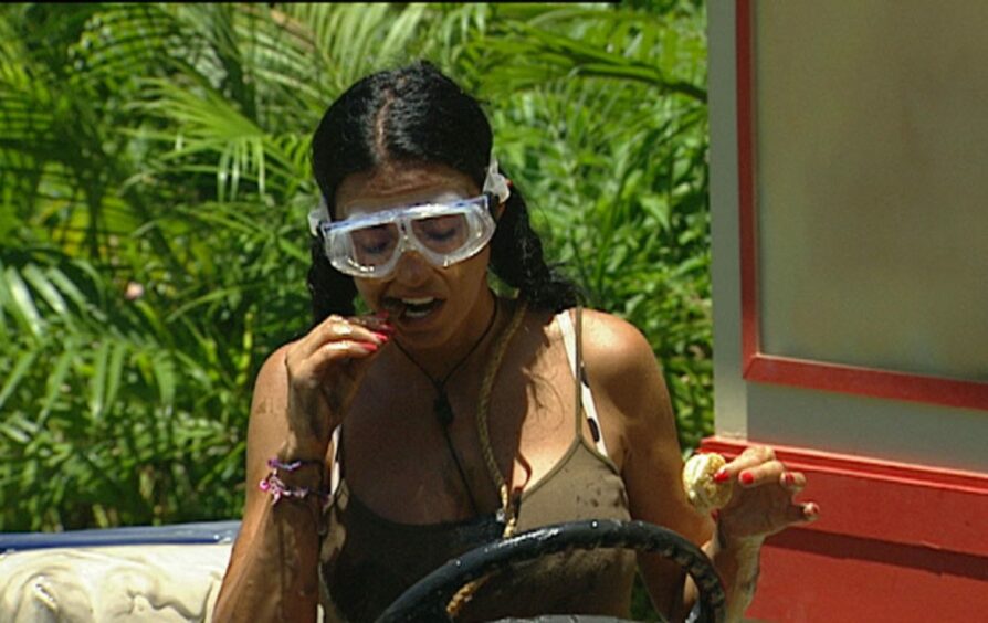Katie Price in vest top and goggles,eating a bug as part of a Bushtucker trial on I'm A Celebrity, Get Me Out Of Here.