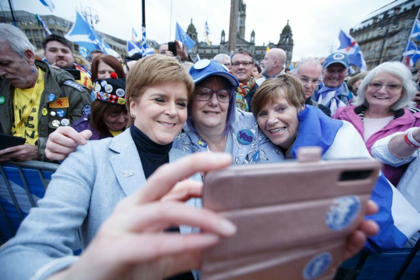 Nicola Sturgeon posing for selfies in a large crowd of Scottish independence supporters.