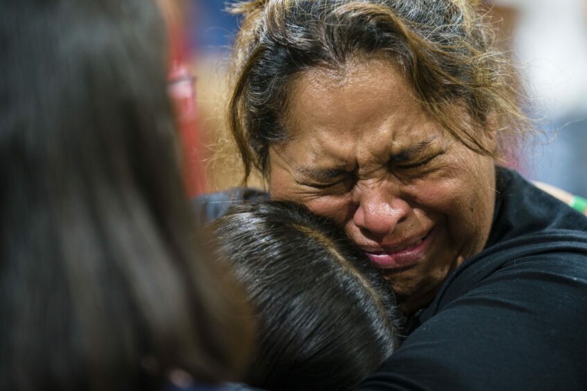 A teacher at Robb Elementary School in Uvalde, Texas, hugs a student at a vigil for the victims