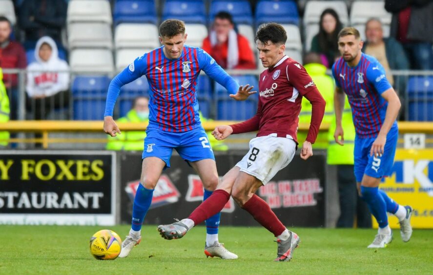 Michael McKenna of Arbroath makes a pass under pressure from Inverness' Reece McAlear.