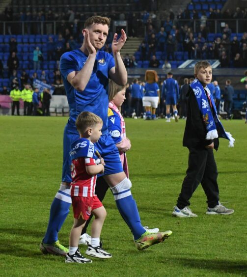 Liam Craig on a lap of honour with his family.