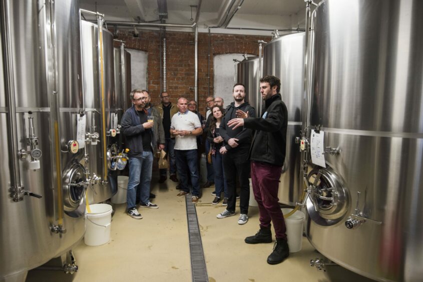 Brewer Gareth Cooper explains the brewing process to guests.