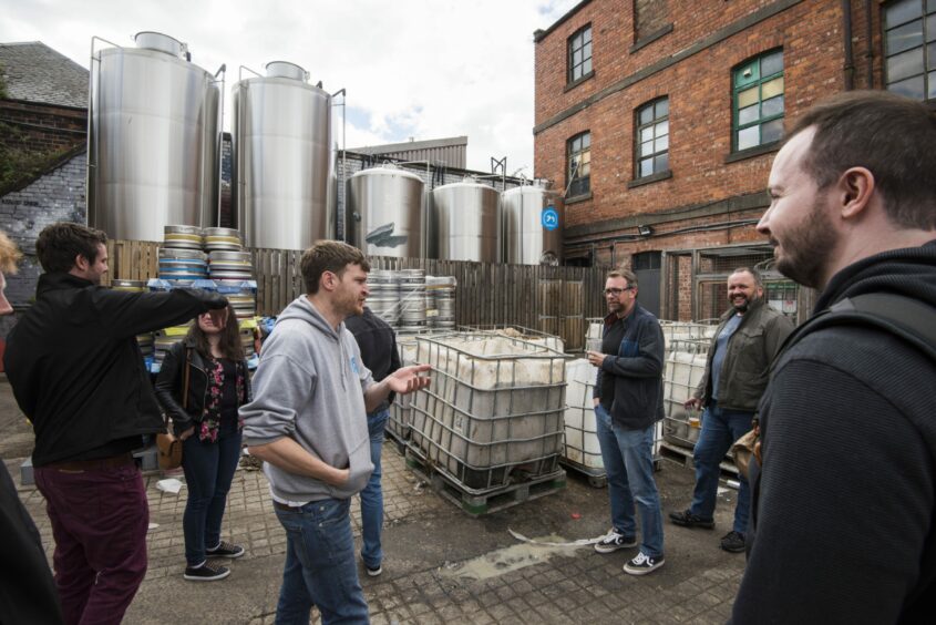 Ross Grattan shows off the giant beer conditioning tanks in the yard.