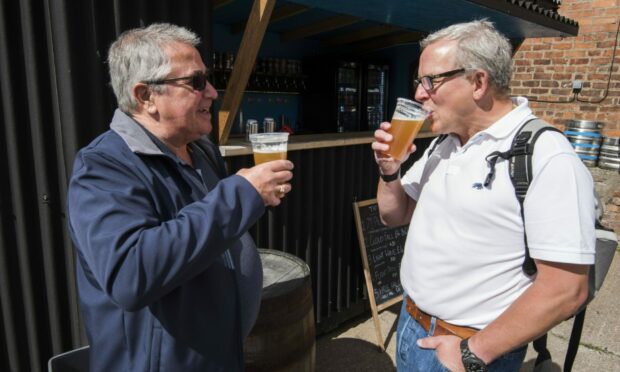 Keith Jackson and Phil Cross enjoy a beer in the beer garden after the tour.