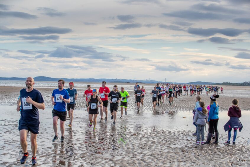 Black Rock 5 runners race along the beach.