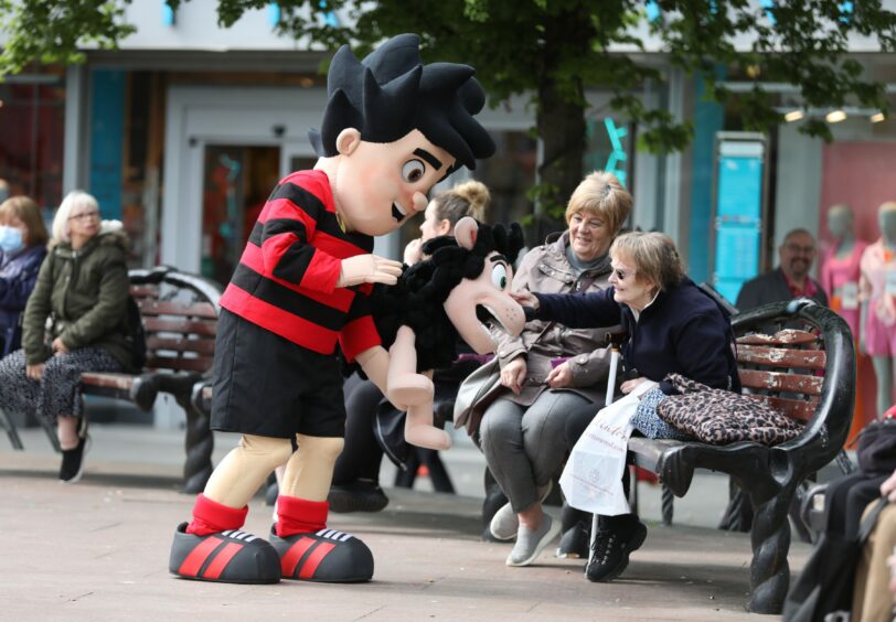 Dennis and Gnasher chatting to locals on High Street in Dundee.