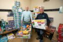 Jim Sorrie and Colin Lamb load up donations at the food larder.