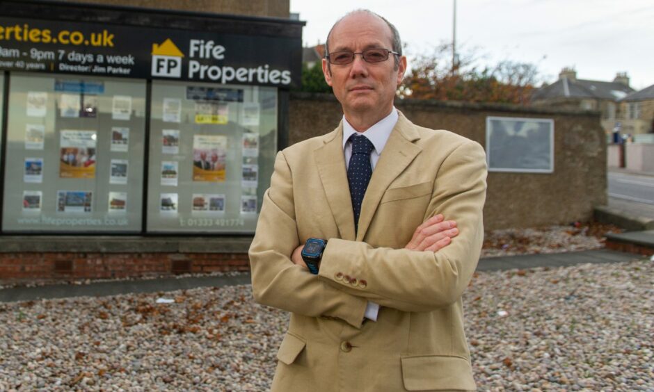 Jim Parker, who runs Fife Properties, stands outside his shop.